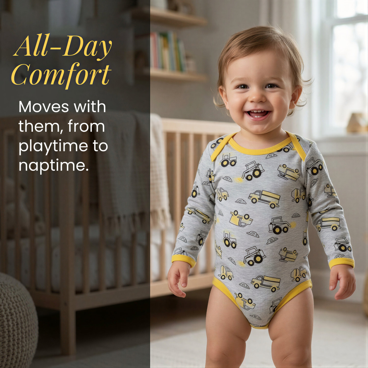 A smiling baby boy wearing a gray and yellow onesie with a truck pattern, standing in a nursery setting.